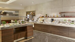 Une cuisine moderne dotée d’un plan de travail en marbre, de meubles en bois et d’une variété de produits alimentaires exposés sur le plan de travail.