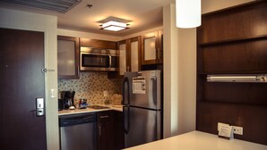 Una cocina compacta con electrodomésticos de acero inoxidable, lavavajillas y microondas.