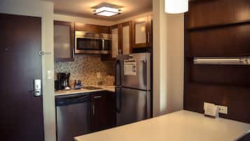 Una cocina compacta con electrodomésticos de acero inoxidable, lavavajillas y microondas.