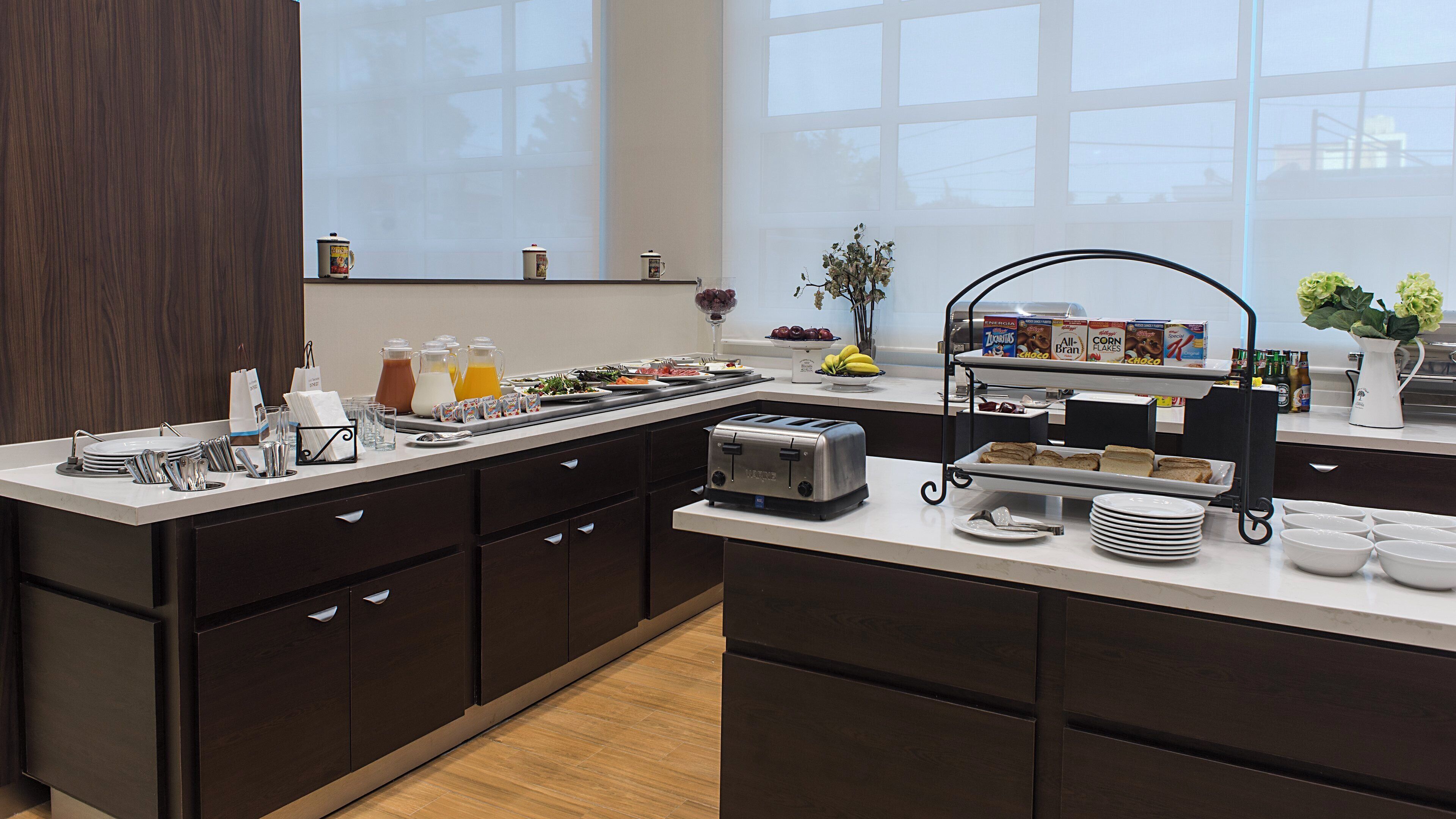 Una cocina moderna con barra desayunadora, un tostador y diversos alimentos.