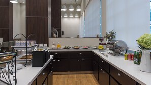 Cocina moderna con bufé de desayuno, que incluye cereales, frutas y bebidas.