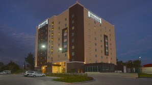 A multi-story hotel with a modern design, featuring a prominent 'Staybridge Suites' sign. - Staybridge Suites Puebla by IHG (Puebla)