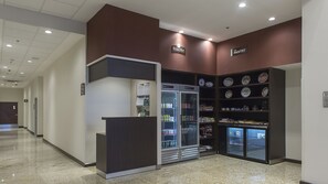 Ein Korridor mit einem BridgeMart und The Pantry, der Kühlgetränkeautomaten und eine Auswahl an Snacks und Backwaren bietet.