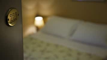 Habitación de hotel con cama, lámpara y puerta con el número 223.