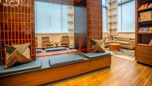 Un salon moderne avec une cheminée, un coin salon et une bibliothèque.