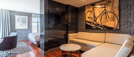 Un salón moderno con un sofá, una mesa redonda y una obra de arte de una bicicleta en la pared.