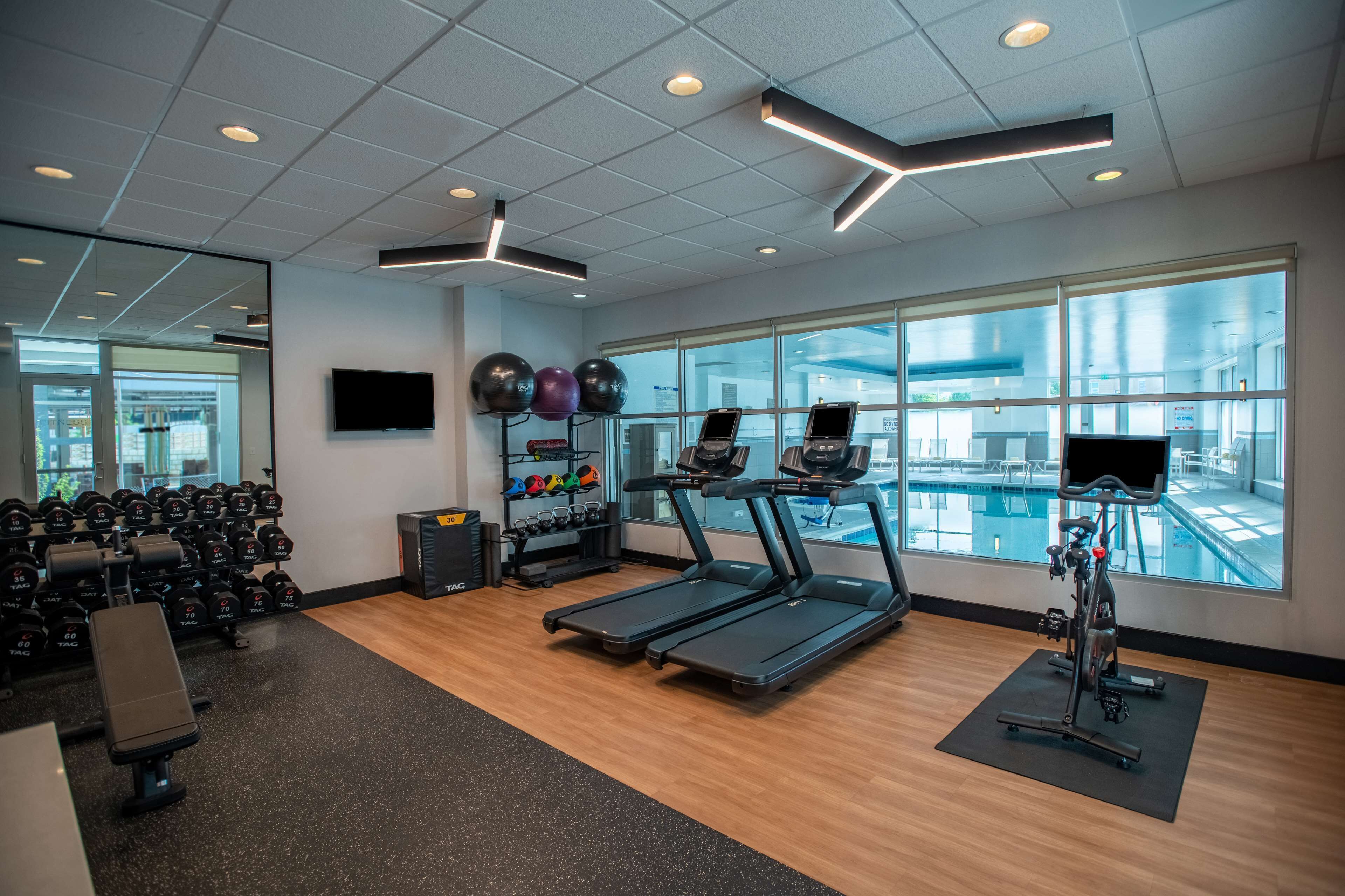 Et moderne fitnesscenter med løbebånd, håndvægte og træningsbolde.