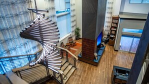 A modern interior with a spiral staircase, a fireplace, and a view of the outdoors. - DoubleTree by Hilton Asheville Downtown (Asheville)