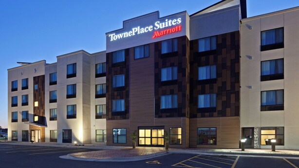 Un hotel TownePlace Suites Marriott con diseño moderno, varios pisos y un estacionamiento.