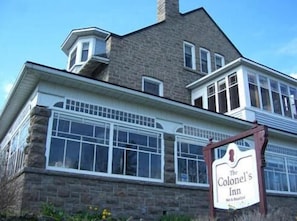 A two-story building with a stone facade and multiple windows. A signboard reads "The Colonel's Inn." - The Colonel's Inn (Prescott)