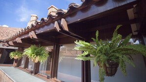 Un edificio con tejado de baldosas tradicionales y plantas colgantes.