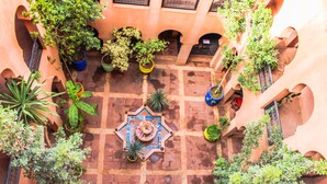 An aerial view of a courtyard with potted plants and a decorative fountain. - Kasbah Omar (Ourika)
