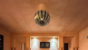 A bedroom with a large bed, a small table, and a patterned rug. - Kasbah Omar (Ourika)