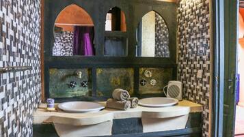 Un baño con un espejo grande, dos lavamanos y un perchero para toallas.