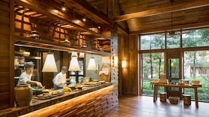 Un restaurante con interior de madera, un ventanal grande y un mostrador de buffet.