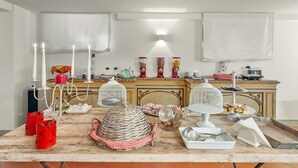 Una cocina con encimera de mármol, armarios blancos y una estufa de estilo vintage.