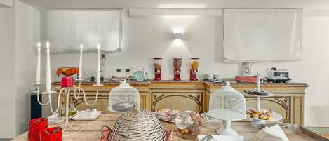 A kitchen with a marble countertop, white cabinets, and a vintage-style stove.