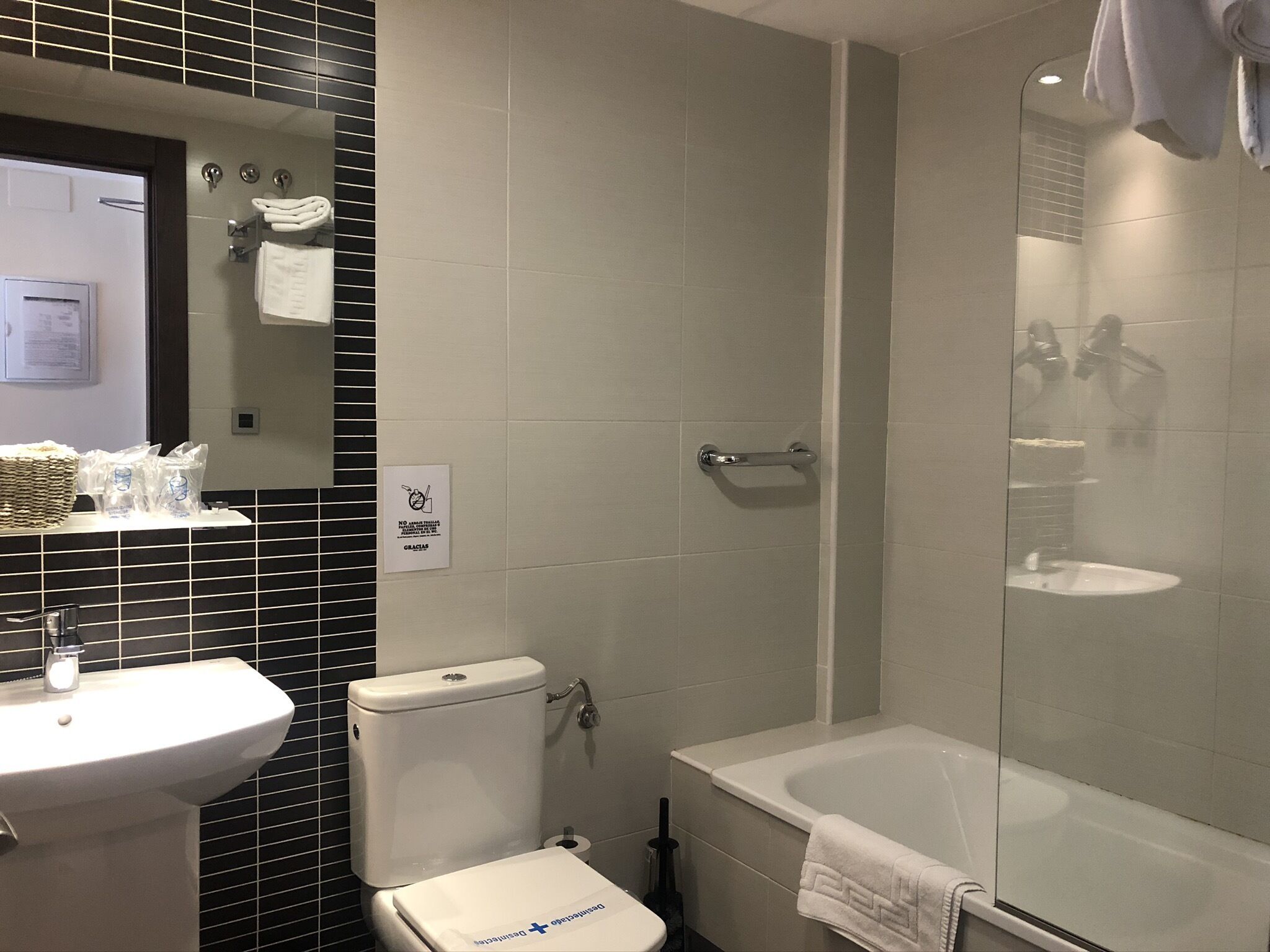 A bathroom with a toilet, sink, and bathtub.