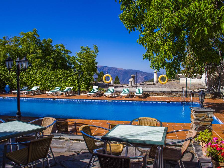 Una piscina al aire libre de temporada, sillones reclinables de piscina