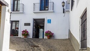 Un edificio blanco con una escalera de piedra que lleva a una puerta marcada con una 'H'.