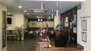 A reception area with a wooden counter, a Toshiba laptop, and a sign indicating 'Salida' (exit).