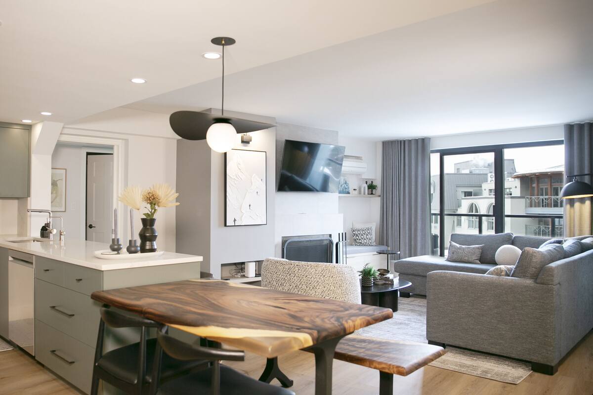 A modern apartment with a kitchen, dining area, and living room.
