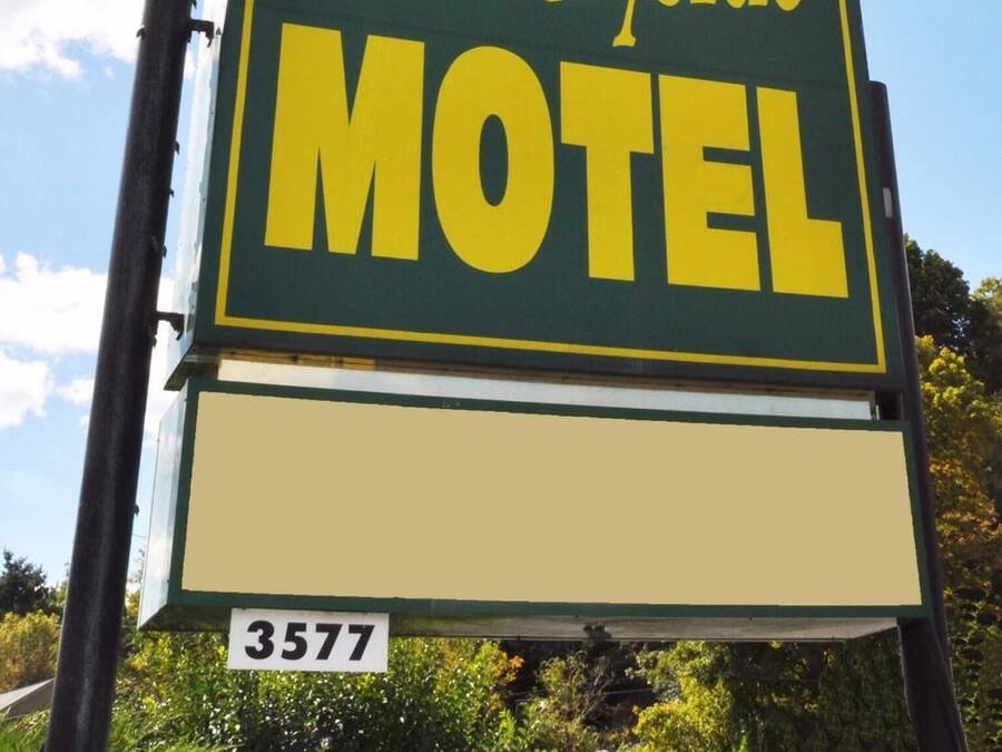 A sign for Countryside Motel with a tree logo and the number 3577.