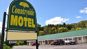 A motel sign with a tree logo, a green and yellow color scheme, and the number 3577. - Countryside Motel (Cold Spring)