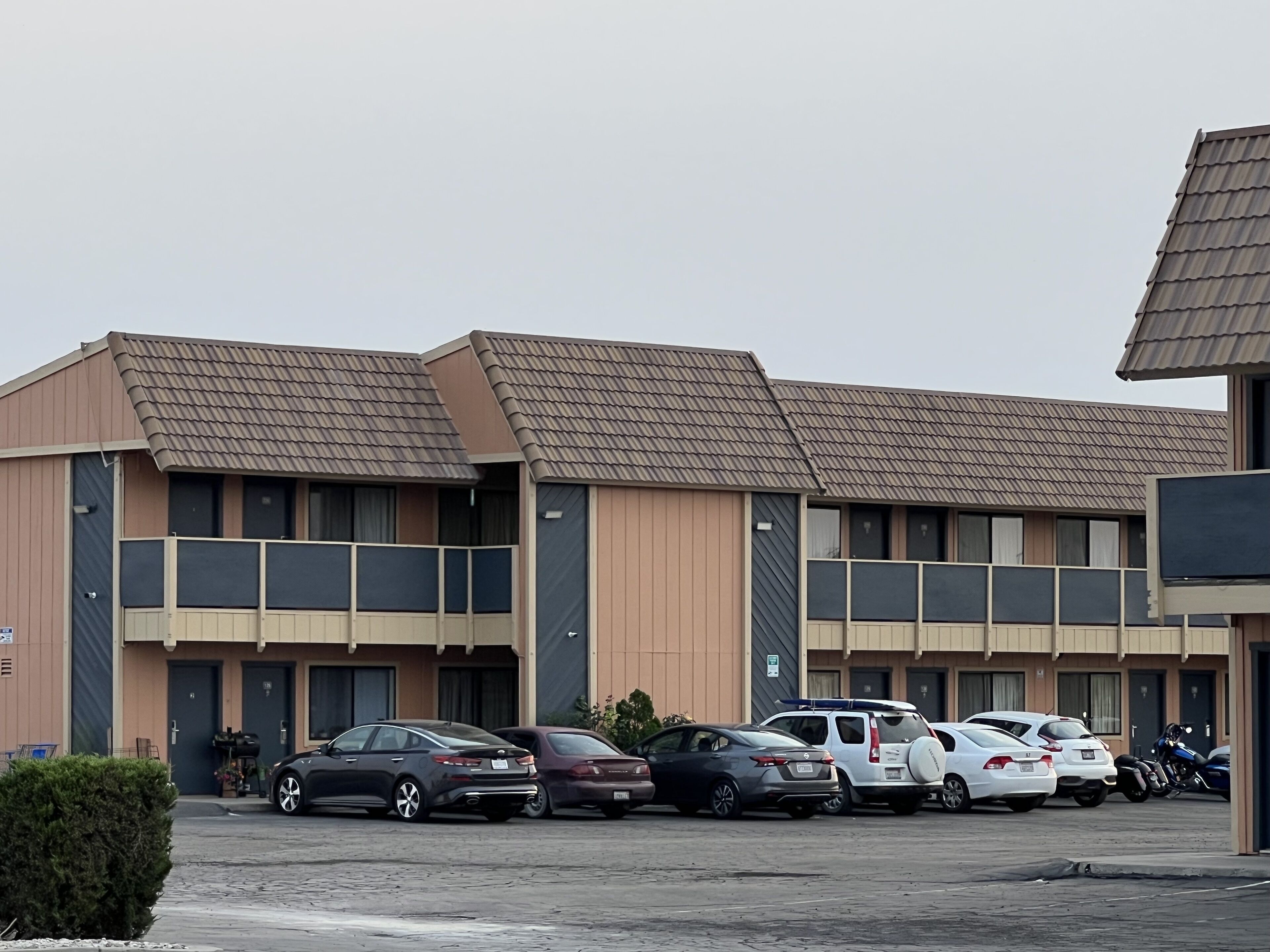 A multi-story motel with a parking lot.