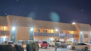 Un motel con varios espacios de estacionamiento y un cartel que indica que es un motel.