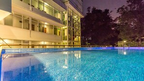 A modern hotel with a swimming pool, featuring a glass facade and multiple balconies. - Sky View Hotel Yangon (Yangon)