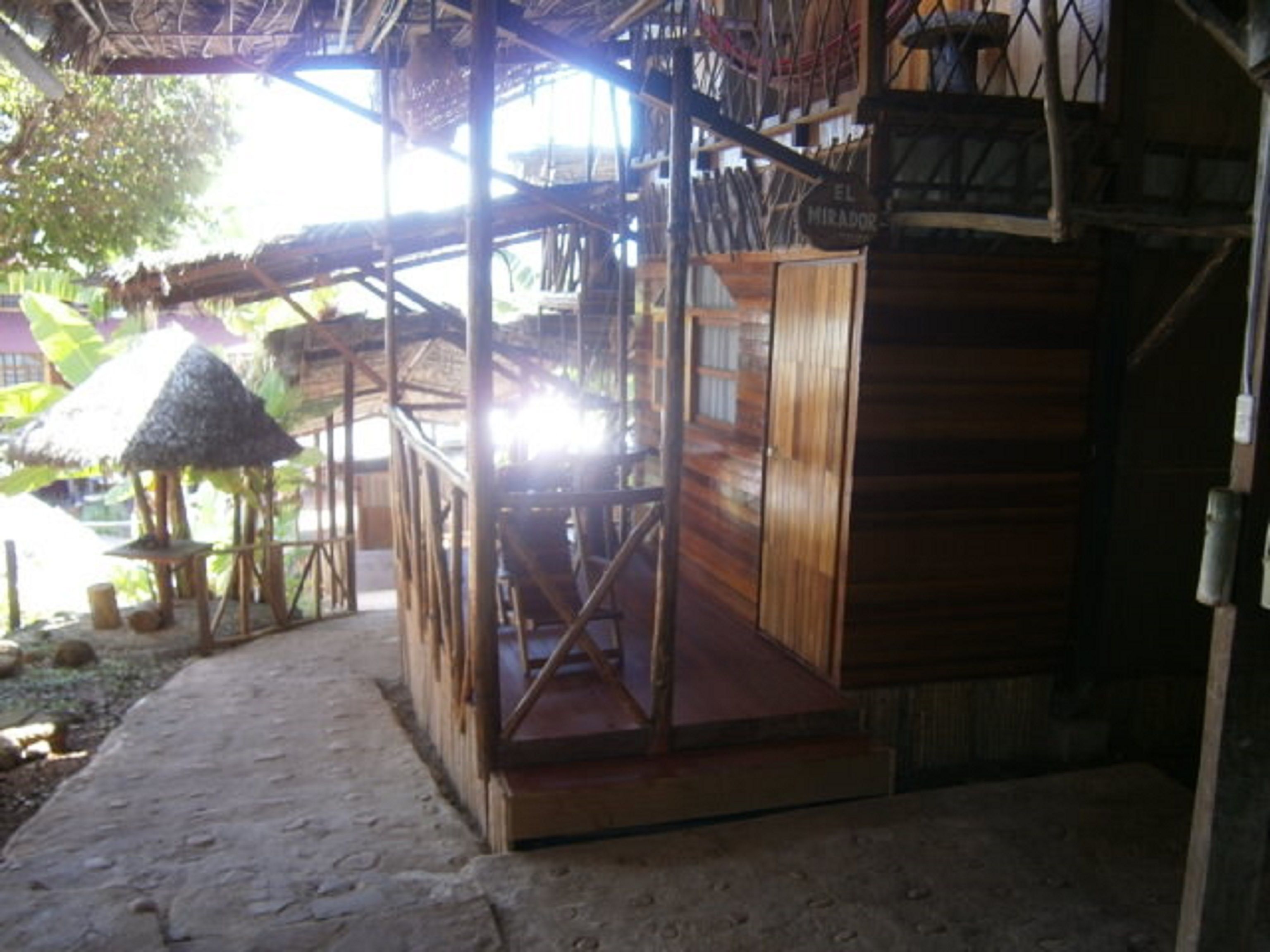 A wooden structure with a thatched roof, a wooden door, and a sign reading "EL MIRADOR".