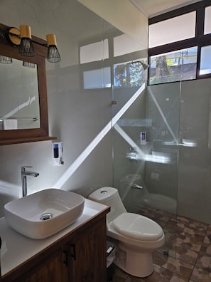 Habitación estándar con 1 cama matrimonial o 2 individuales, vista al jardín | Baño | Regadera, toallas, jabón, shampoo