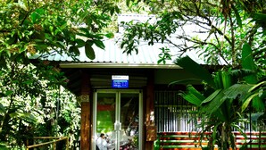 A reception area with a signboard, a bench, and a metal gate.