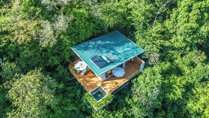 A square-shaped building with a green roof, surrounded by dense green foliage. - El Remanso Rainforest Lodge (Puerto Jiménez)