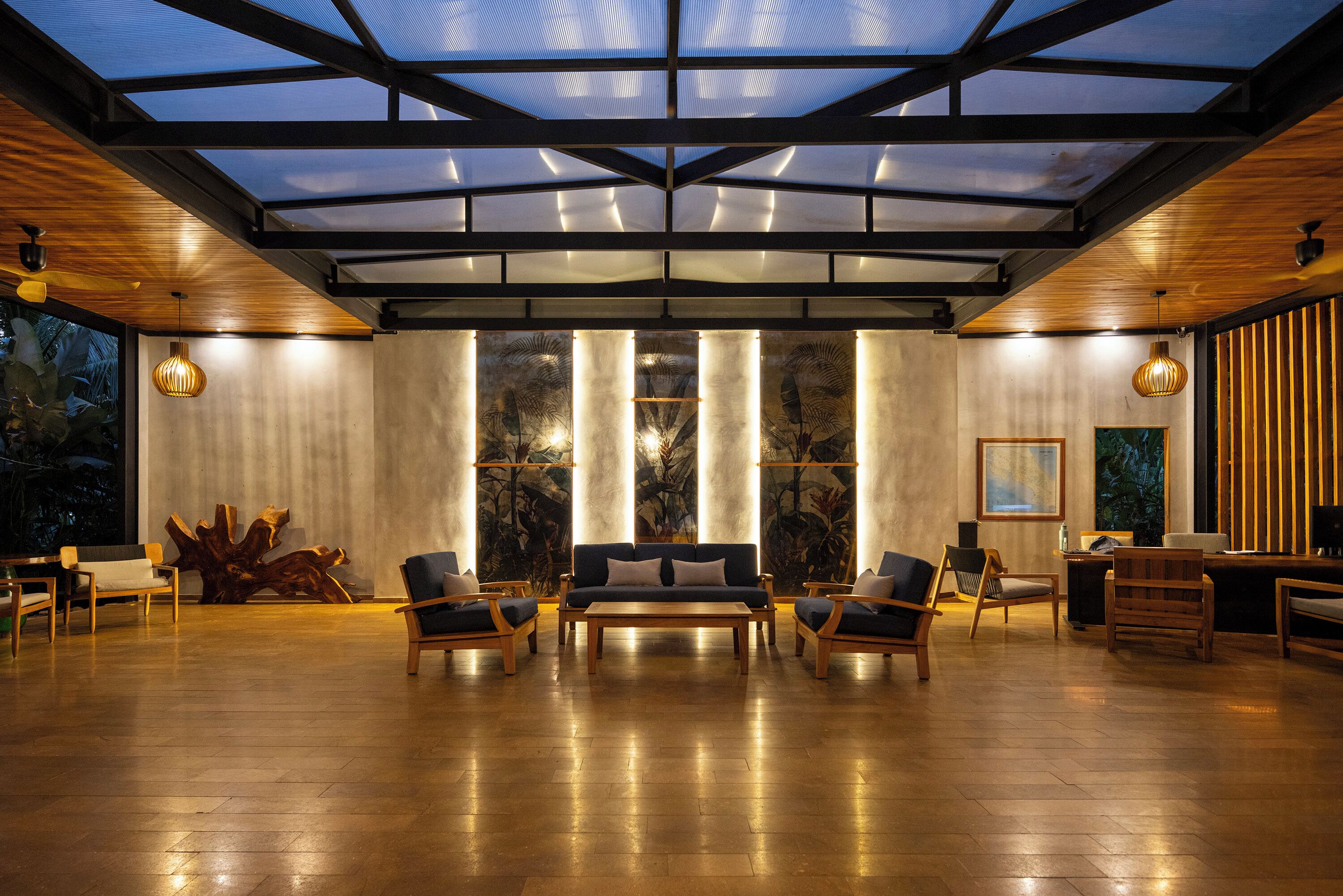 A spacious room with a large wooden coffee table, two sofas, and chairs arranged for a social setting.