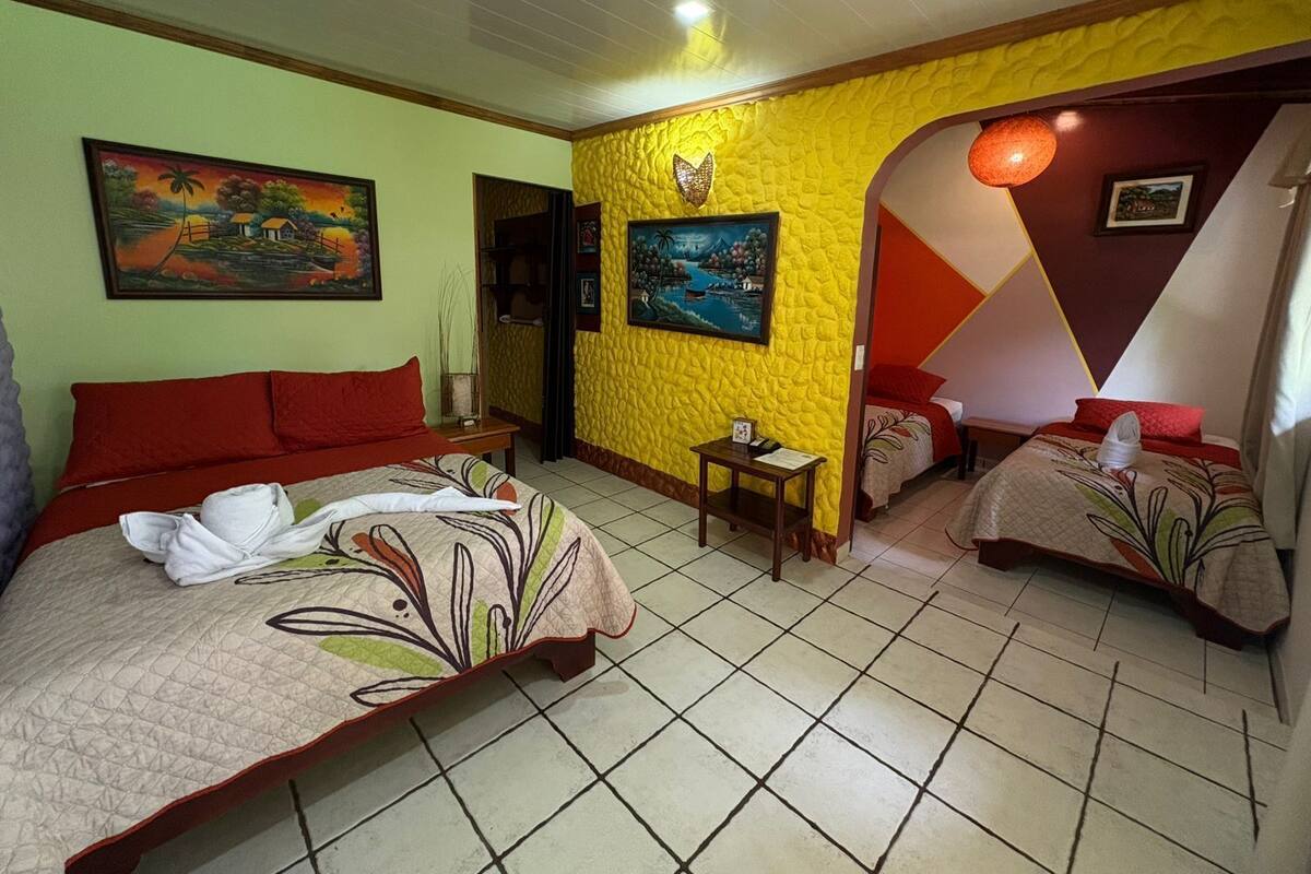 Une chambre d’hôtel avec deux lits, une petite table et un tableau au mur.