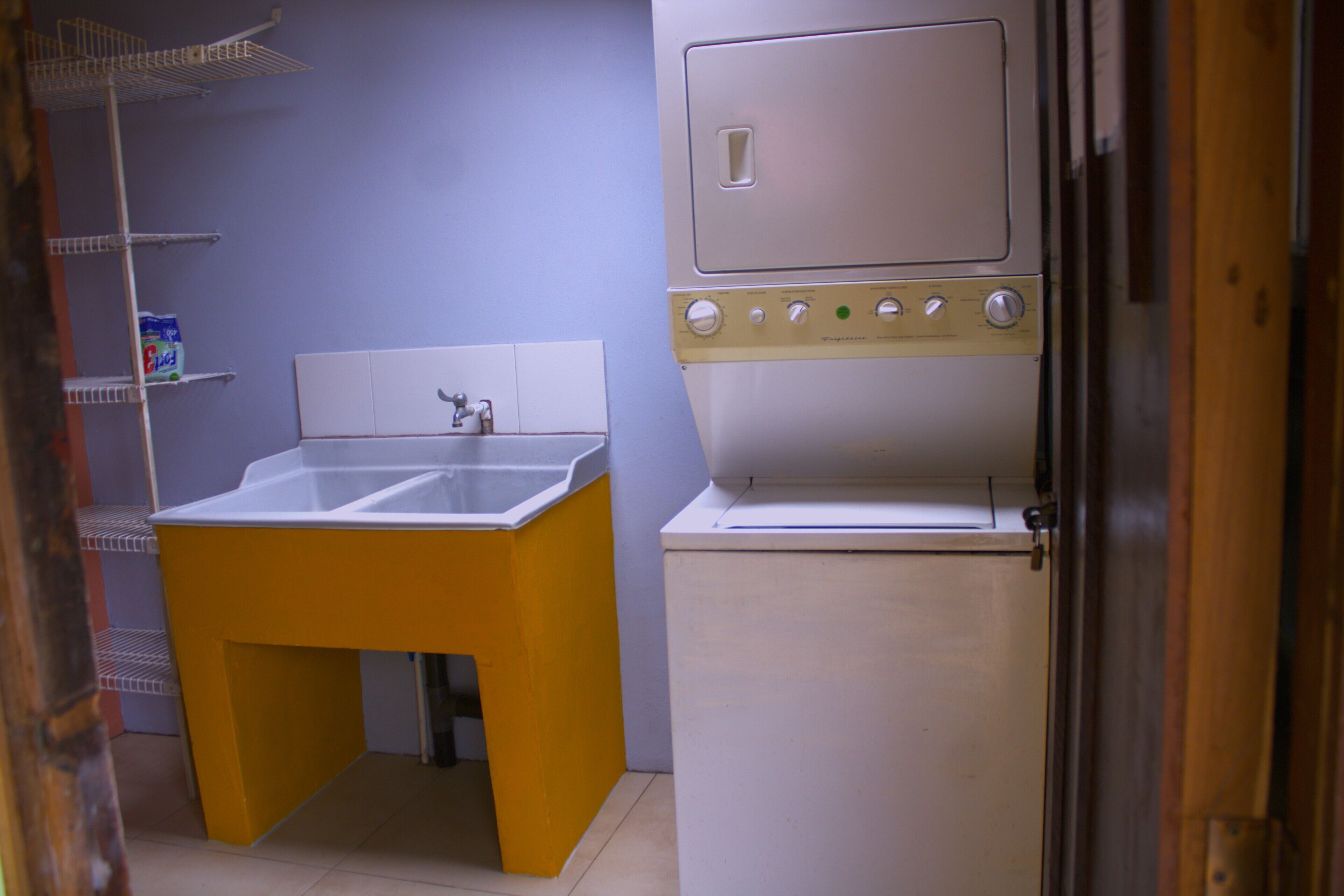 A compact kitchen with a sink, a built-in oven, and a refrigerator.