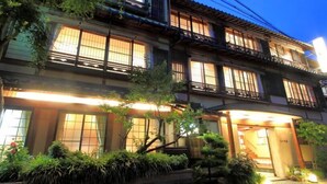 A traditional Japanese building with multiple windows and a well-lit entrance. - Sinonomesou (Toyooka)