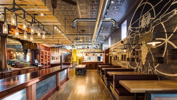 A restaurant interior with a bar area, wooden tables, and a mural on the wall. - Cottonwood Hotel (Cottonwood)