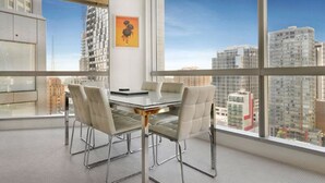 Une salle de conférence moderne, dotée d’une table en verre et de fauteuils en cuir, ainsi que de grandes fenêtres offrant une vue sur la ville.