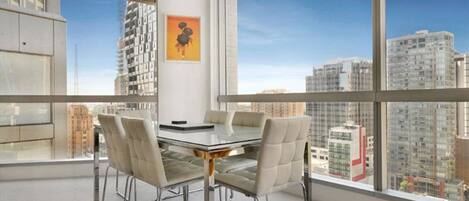 Una sala de conferencias moderna con una mesa de vidrio y sillas de cuero, amplias ventanas con vistas a la ciudad.