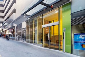 A modern building with large glass windows and a green facade. - StayCentral - Melbourne Central (Melbourne)