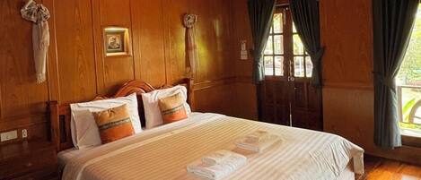 A large, wooden-paneled bedroom with a high ceiling and a skylight.