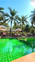 Una piscina al aire libre, sillones reclinables de piscina