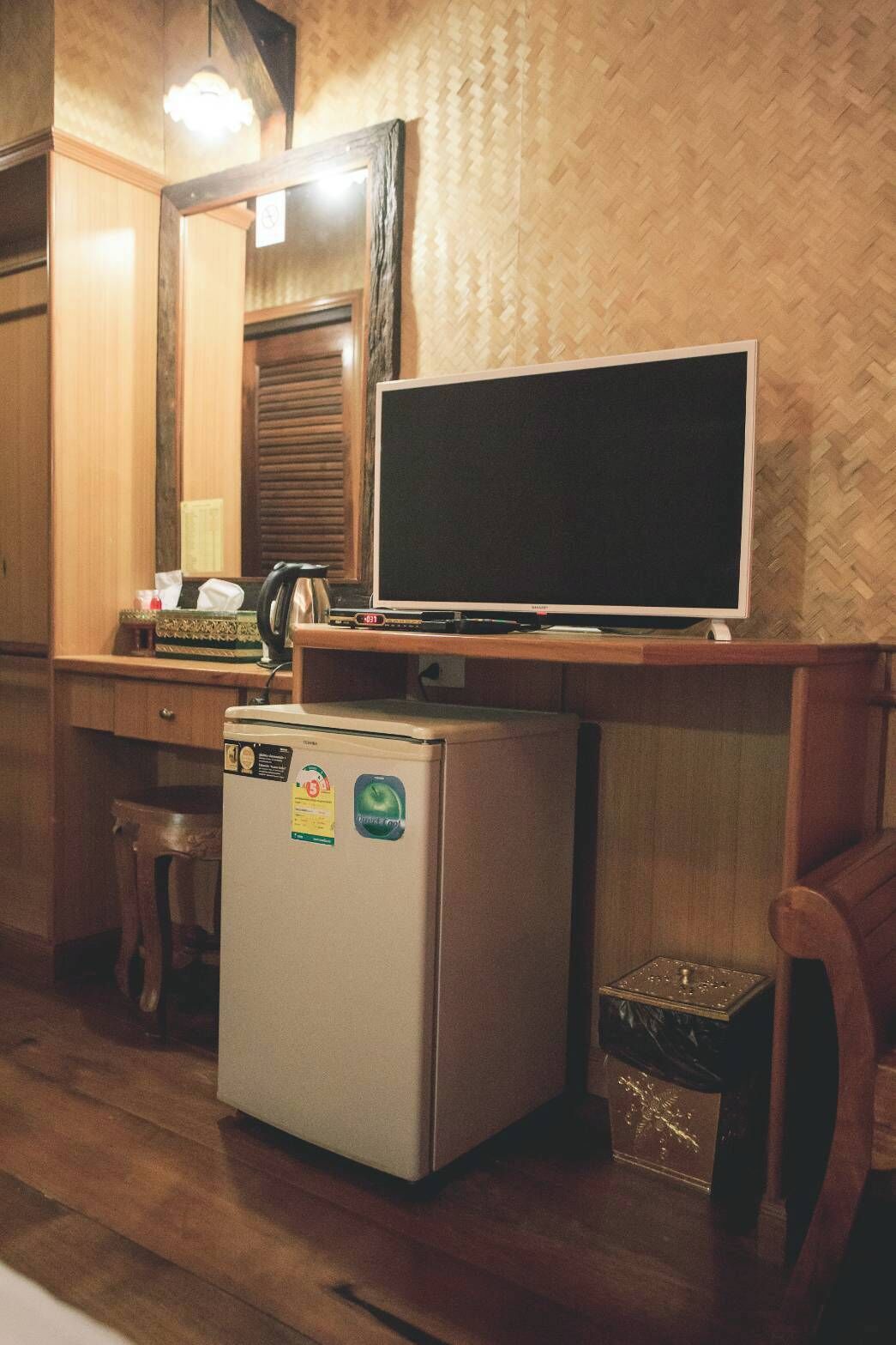 A compact kitchen with a refrigerator, a microwave, and a small countertop with a kettle.