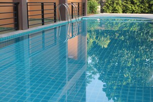 Una piscina al aire libre, tumbonas