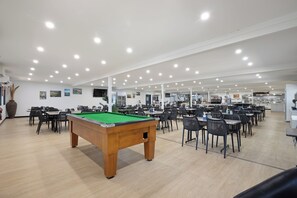 A spacious indoor area with a pool table, multiple dining tables, and chairs. - Aspen Karratha Village (Baynton)