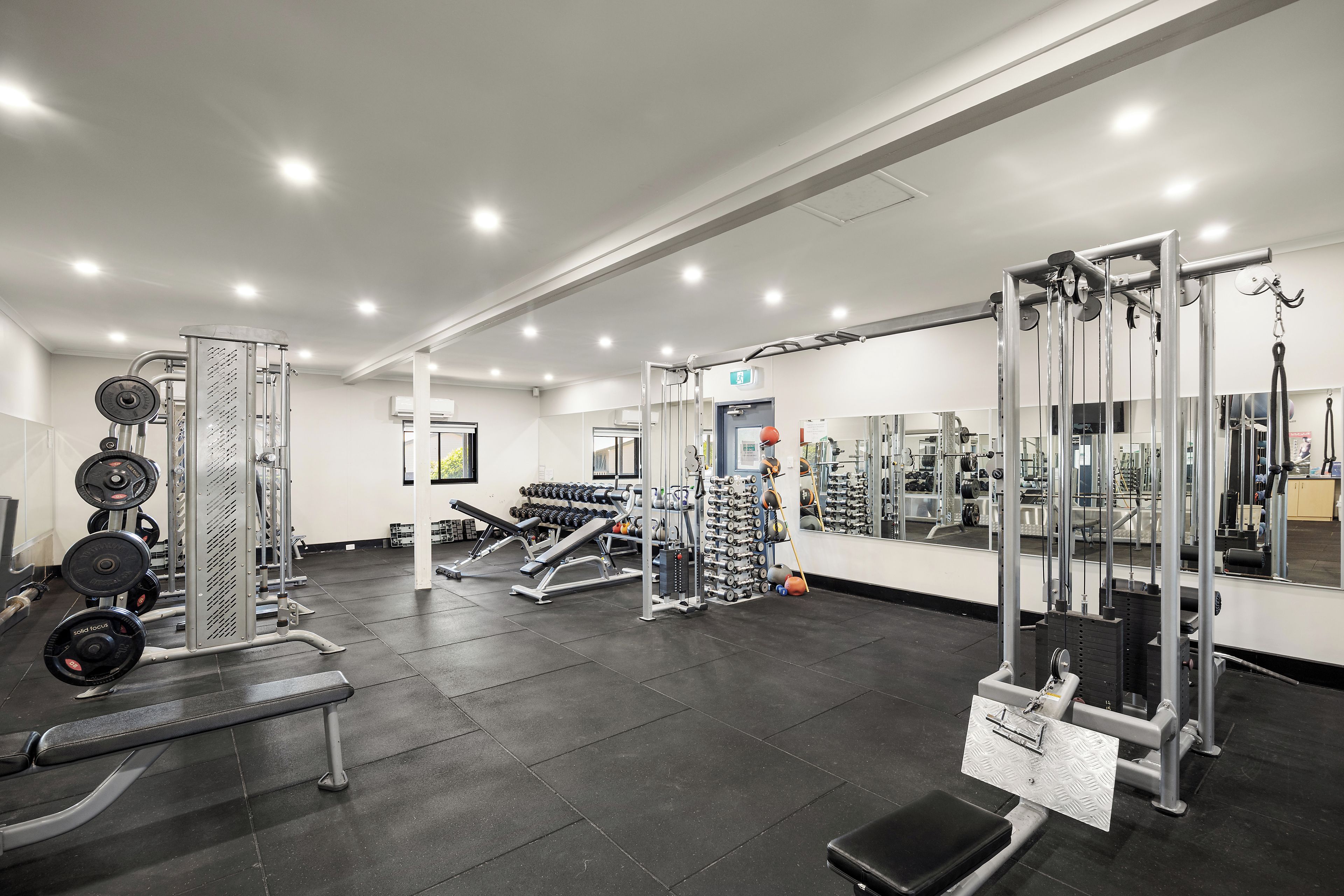 A gym with various exercise equipment, including weight machines and free weights.