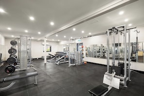 A gym with various exercise equipment, including weight machines and free weights. - Aspen Karratha Village (Baynton)